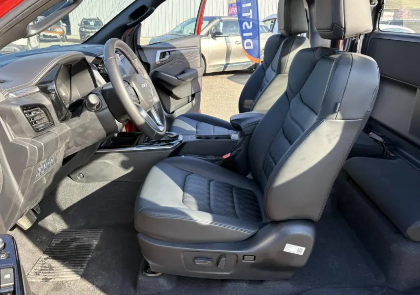 Vue intérieure côté conducteur de l'Isuzu D-MAX 2026 avec sièges en cuir noir et tableau de bord moderne.