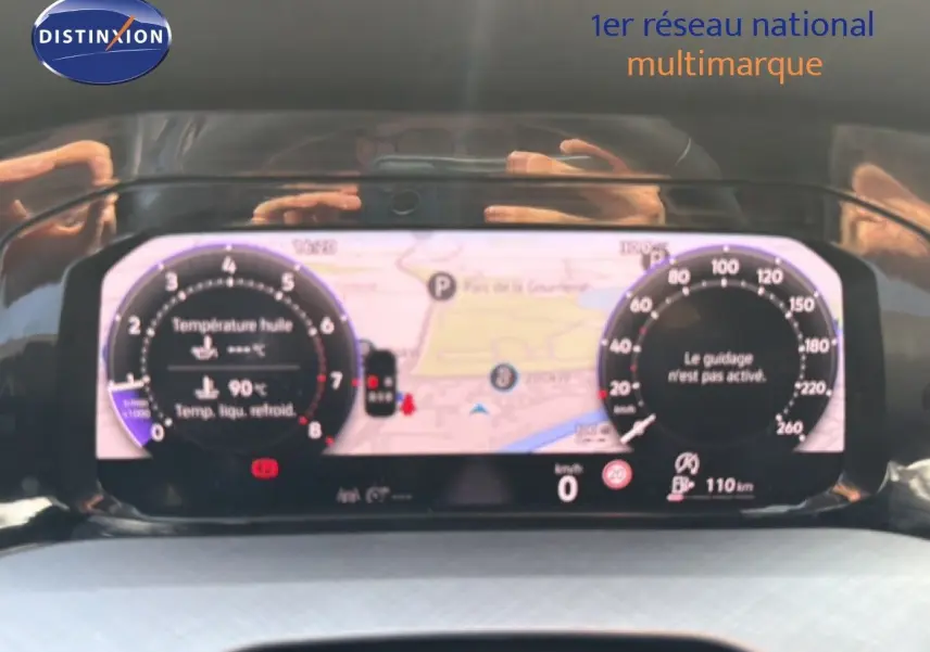 Vue rapprochée du tableau de bord numérique de la Volkswagen Golf SW bleu Anemone, affichant la navigation et les jauges.