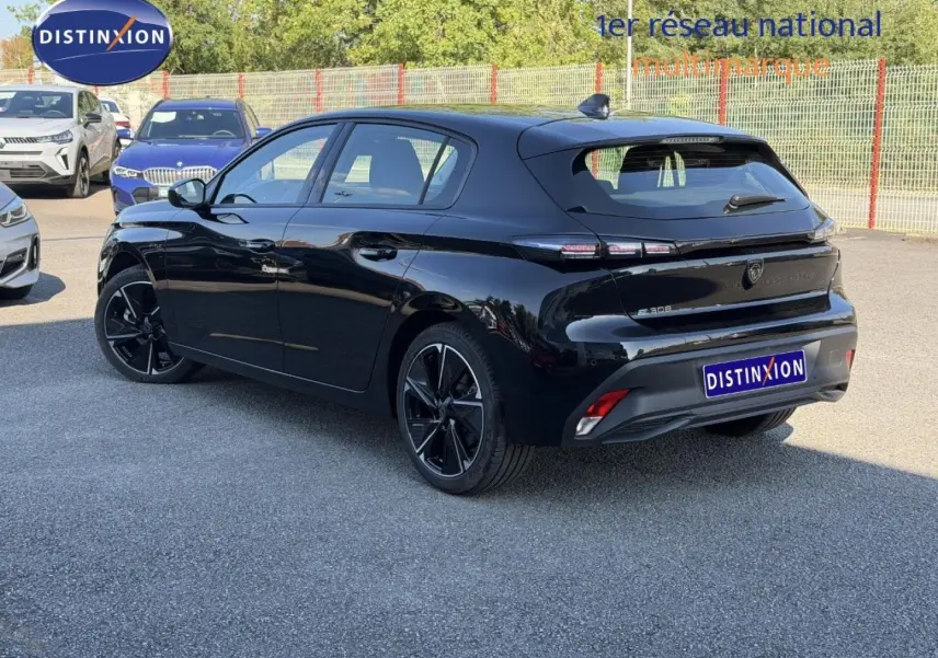 Vue 3/4 arrière droite d’une Peugeot e-308 noire Perla Nera avec jantes alu et feux arrière LED distinctifs.
