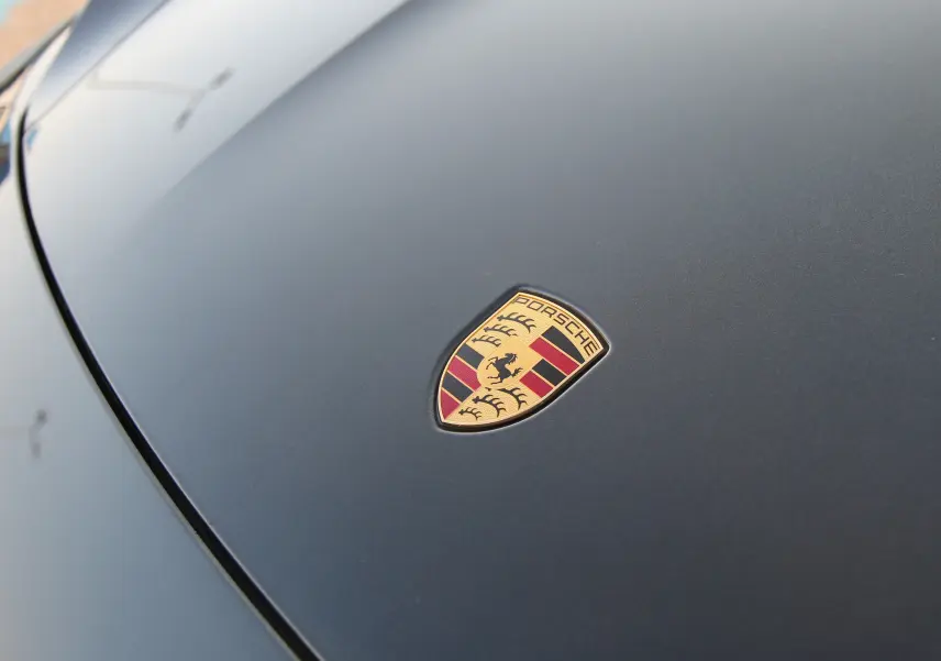 Gros plan sur l'écusson Porsche sur le capot gris anthracite d'une Taycan Turbo électrique 2020.