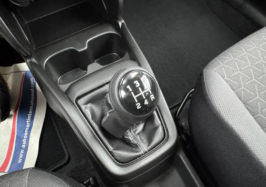 Gros plan sur le levier de vitesses manuel noir de la Suzuki Swift 1.2 Privilège Hybrid 2025, intérieur gris.