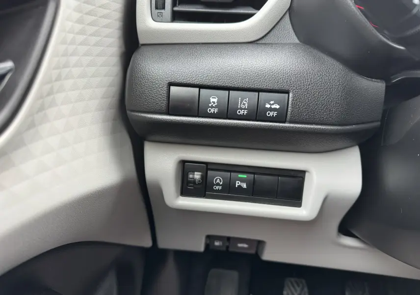 Gros plan sur les commandes de sécurité et assistance côté gauche du tableau de bord de la Suzuki Swift 1.2 Privilège Hybrid 2025.