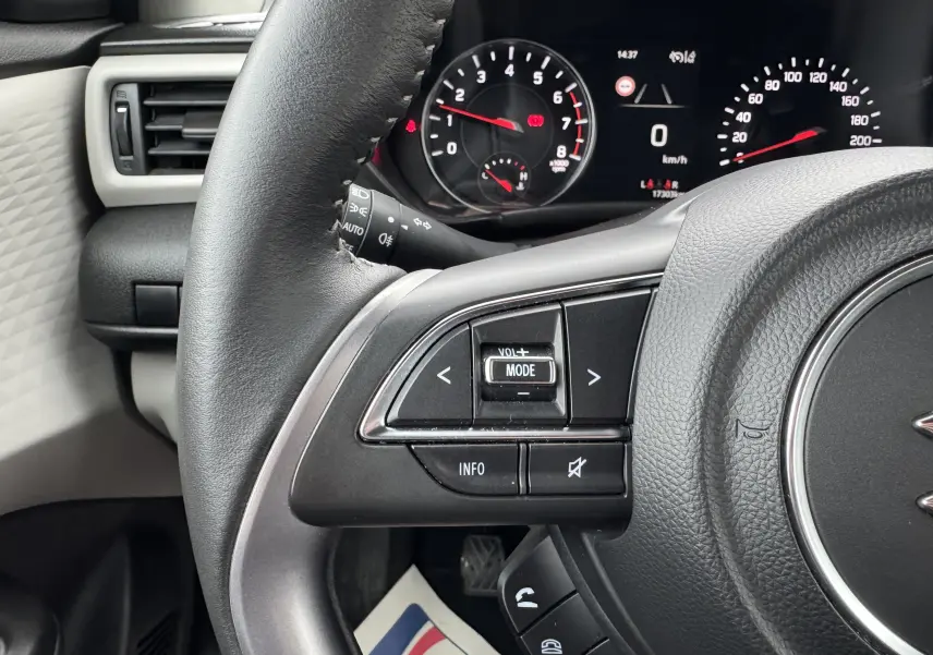 Gros plan sur le volant et le tableau de bord digital de la Suzuki Swift 1.2 Privilège Hybrid 2025, intérieur noir.