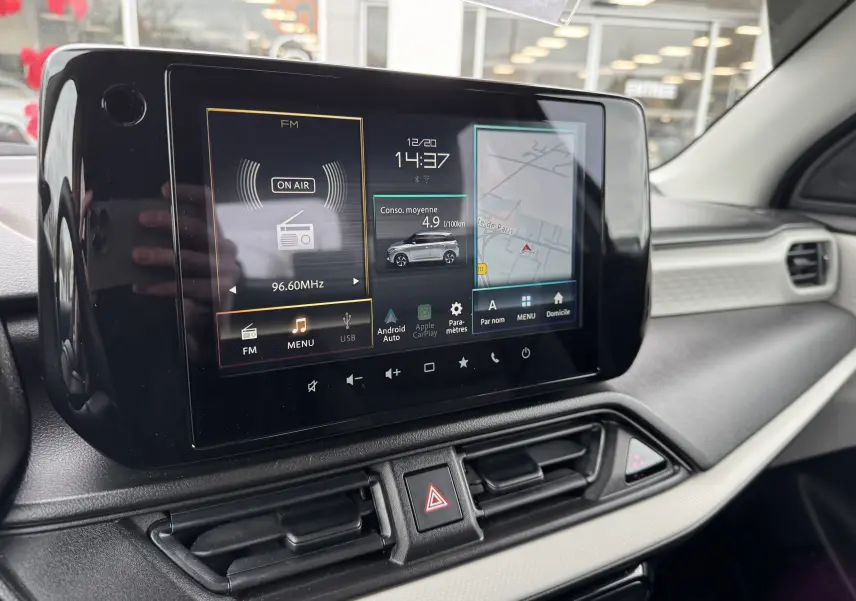 Écran tactile central de la Suzuki Swift 1.2 Privilège Hybrid 2025, affichant radio, consommation et navigation.