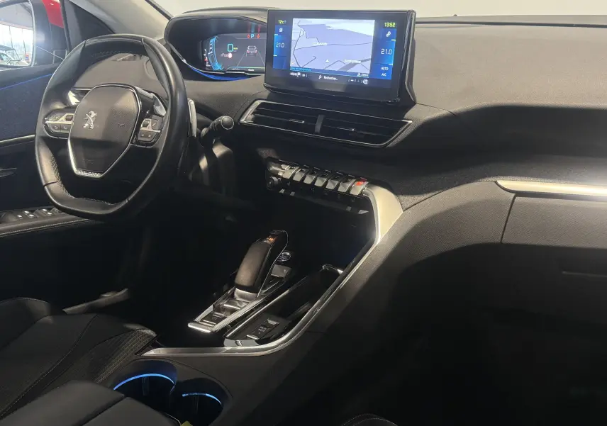 Intérieur du Peugeot 3008 Hybrid 2025 vu côté conducteur, tableau de bord avec écran tactile et levier de vitesses automatique.