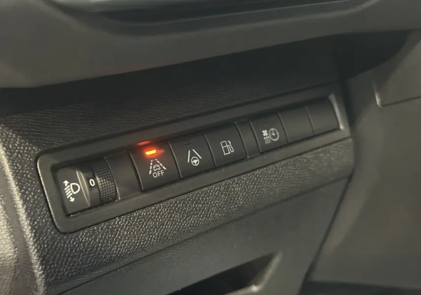 Gros plan sur les commandes intérieures du tableau de bord du Peugeot 3008 Hybrid 2025, avec témoin d’alerte activé.
