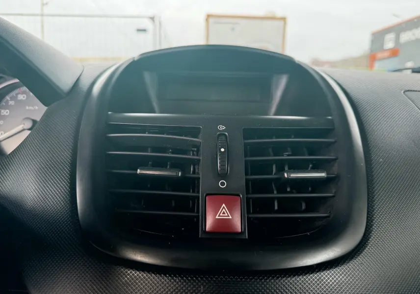 Gros plan sur la commande d’essuie-glace noire et le tableau de bord noir de la Peugeot 206+ 1.1 i 60.