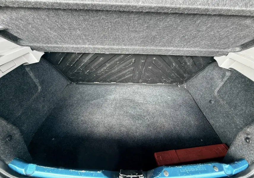 Intérieur de la Peugeot 206+ 2011, vue du vide-poche passager ouvert avec documents à l’intérieur.