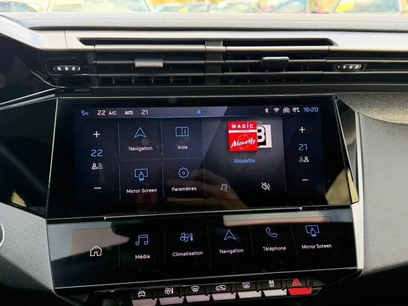 Vue rapprochée de l’écran tactile central noir du tableau de bord de la Peugeot 308 2024 Rouge Elixir.