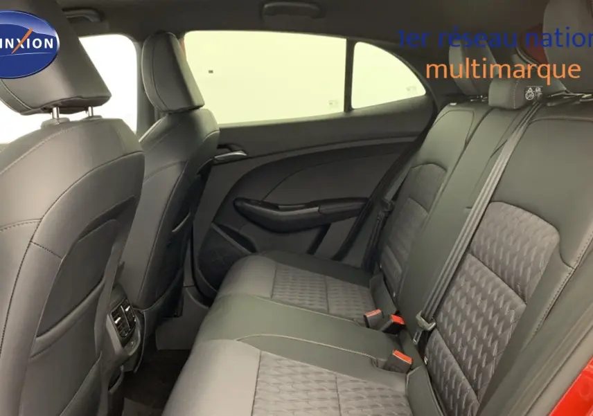 Vue intérieure arrière du siège arrière en similicuir noir de la MG3 1.5 L Hybrid+ Diamond Red, avec portières ouvertes.