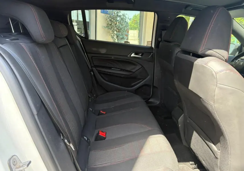 Vue intérieure côté droit sur la banquette arrière noire avec surpiqûres rouges d’une Peugeot 308 GT-Line blanche de 2017.
