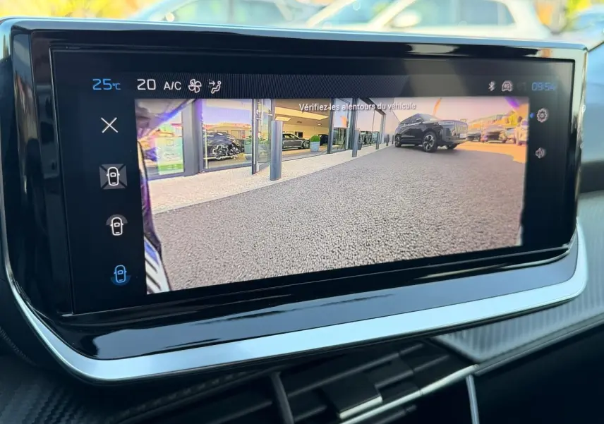 Écran tactile intérieur montrant la caméra de recul avec vue sur un SUV noir en extérieur, jour ensoleillé.
