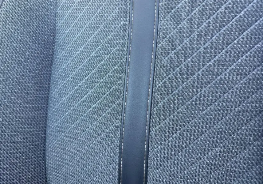 Détail du tissu gris Casual Lomsa avec surpiqûres et bande centrale en simili cuir sur siège Peugeot 208 2025.