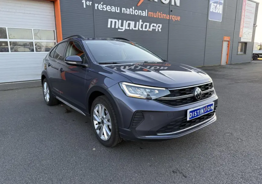 Volkswagen Taigo 2025 gris INC en 3/4 avant droit, avec jantes alliage et feux LED allumés.