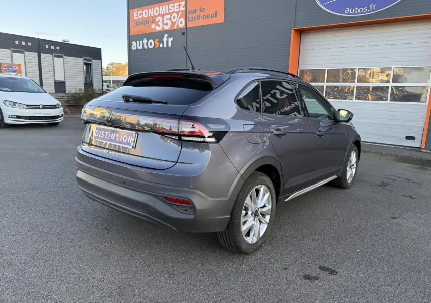 Vue 3/4 arrière droite d'un Volkswagen Taigo gris INC avec jantes alliage et vitres arrière surteintées.