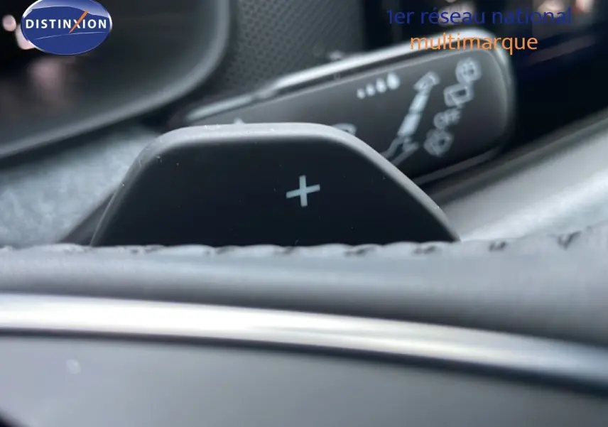 Gros plan sur la palette de passage de vitesse "+" du volant dans l'habitacle gris graphite du Skoda Kamiq 2025.