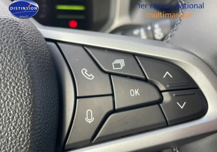 Gros plan sur les commandes multifonctions au volant du Dacia Duster 2026, finition Journey, en vert cèdre.