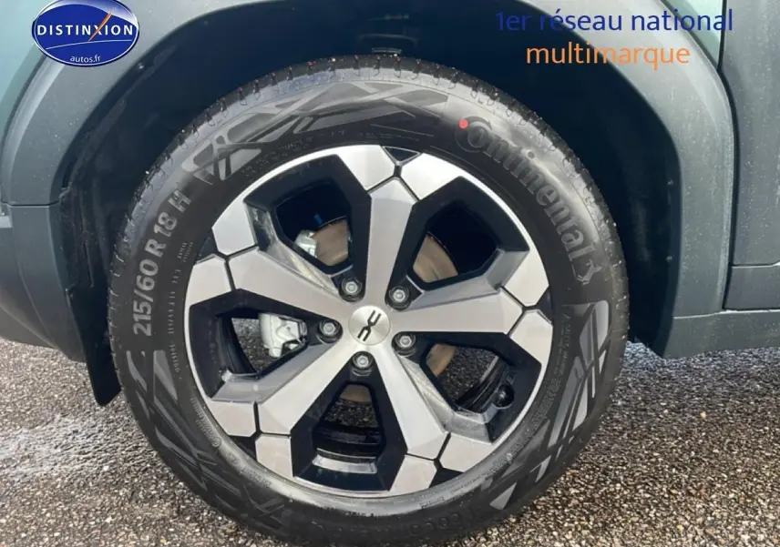Gros plan sur la roue avant droite du Dacia Duster 2026 vert cèdre avec jante alu bicolore et pneu Continental.