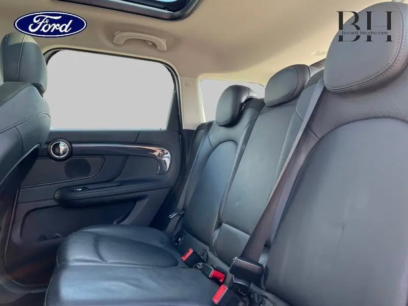 Vue intérieure arrière côté droit du MINI Countryman Cooper SE 2018 avec sièges cuir noir et toit panoramique.