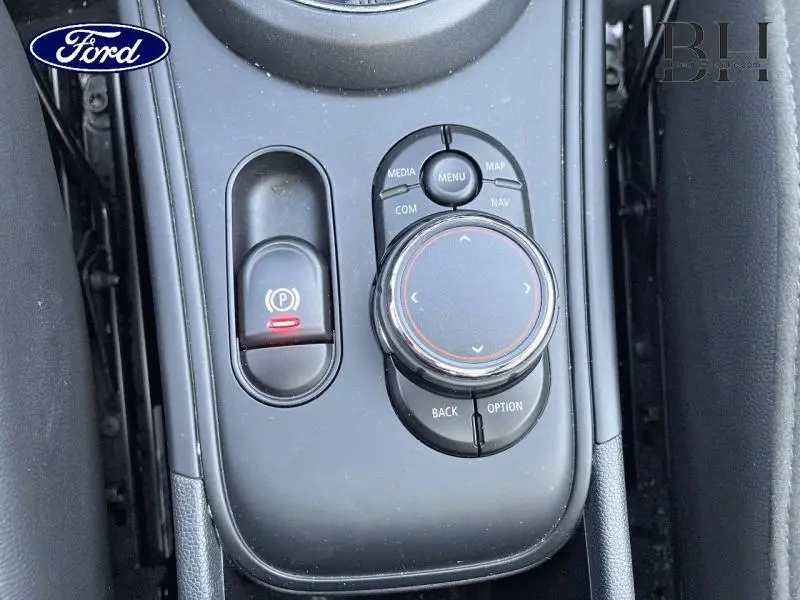 Gros plan sur la molette de commande centrale noire et le frein à main électronique du MINI Countryman Moonwalk Grey.