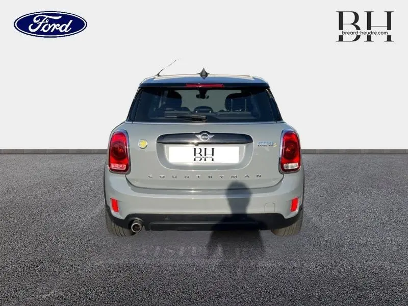 Vue arrière d'une MINI Countryman Cooper SE Moonwalk Grey avec toit panoramique et échappement chromé visible.