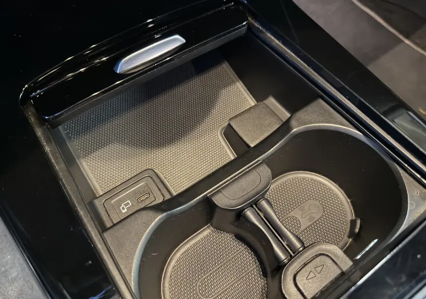 Gros plan sur le porte-gobelets noir brillant et prise USB dans la console centrale d’une Mercedes Classe A noire.