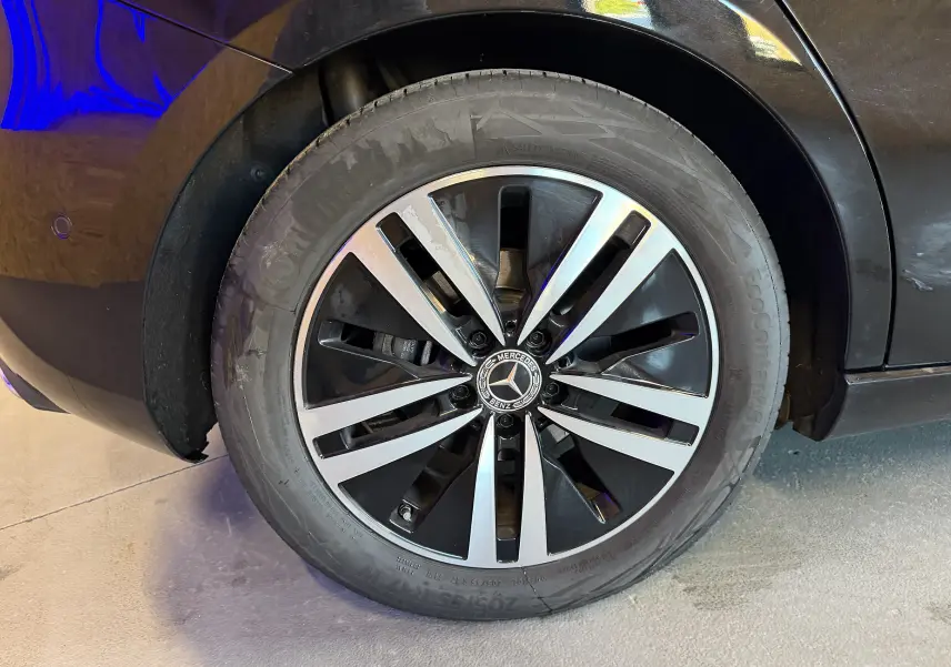 Gros plan sur la jante alu bicolore noire et argentée d’une Mercedes Classe A noire, vue côté arrière droit.