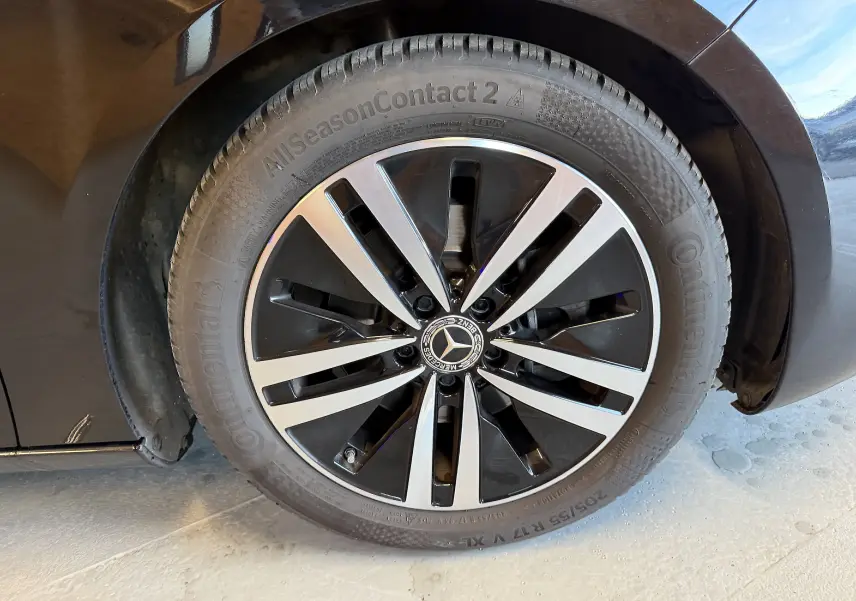 Gros plan sur la jante alu noire et argentée de la Mercedes Classe A noire, mettant en valeur le logo central étoilé.