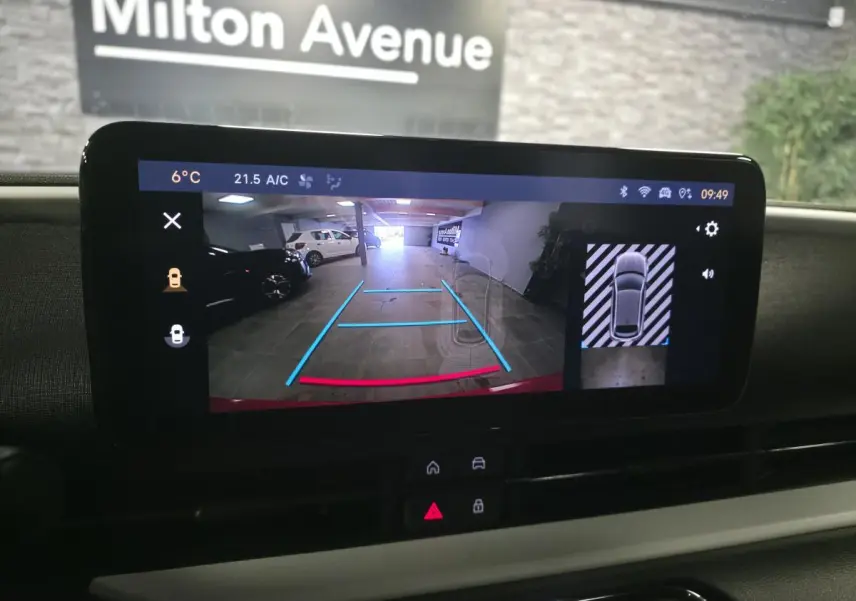 Écran tactile intérieur montrant la caméra de recul et l’aide au stationnement 360° du Fiat 600 rouge 2024.