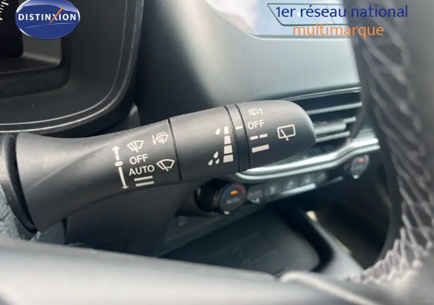 Gros plan sur la manette d'essuie-glace à gauche du volant dans l'habitacle du Nissan Juke rouge Fuji Metal 2024.