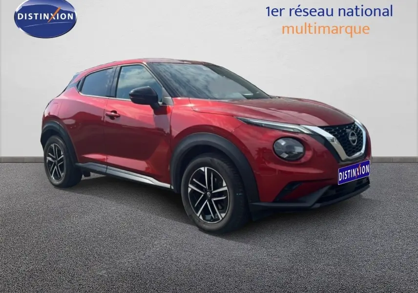 Nissan Juke rouge Fuji Metal en 3/4 avant droit, avec jantes alliage et calandre chromée distinctive.