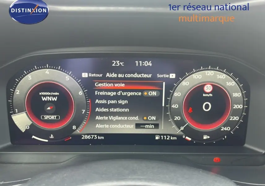 Tableau de bord numérique du Nissan Juke rouge Fuji, affichant les aides à la conduite et compteurs à 0 km/h.