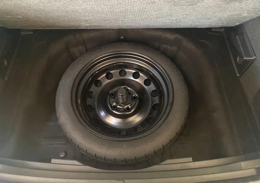 Roue de secours noire en acier logée dans le coffre d'un SEAT Ateca Urban 2019 diesel 1.6l TDI.