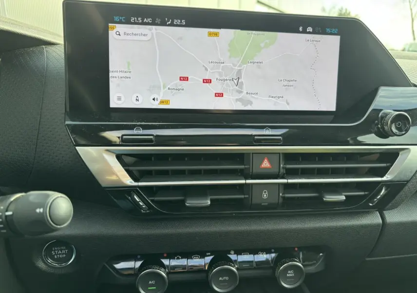 Vue rapprochée du tableau de bord de la Citroën C4 2024 gris Artense, avec écran tactile GPS et commandes climatisation.