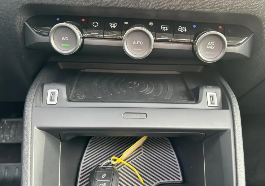 Détail de la console centrale de la Citroën C4 2024 avec commandes climatisation et zone de recharge sans fil.