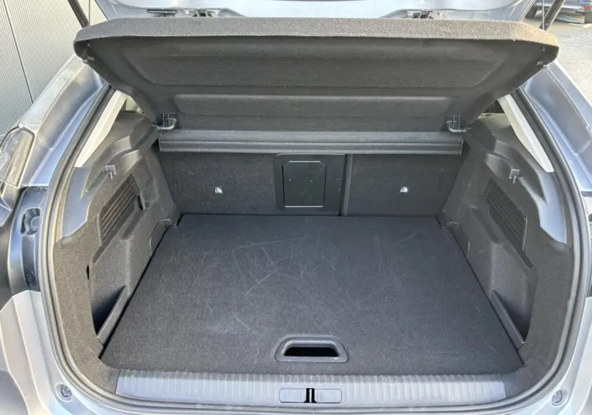 Coffre ouvert vu de l'arrière d'une Citroën C4 2024 gris Artense, espace de chargement propre et volumineux.