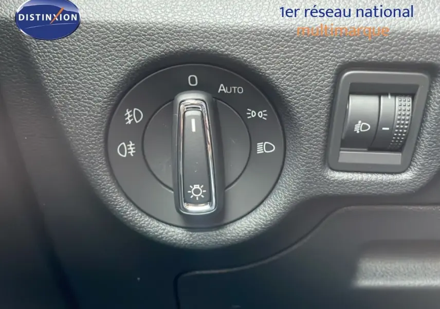 Gros plan sur la molette de commande des phares du Skoda Kamiq 2025 en intérieur noir texturé.