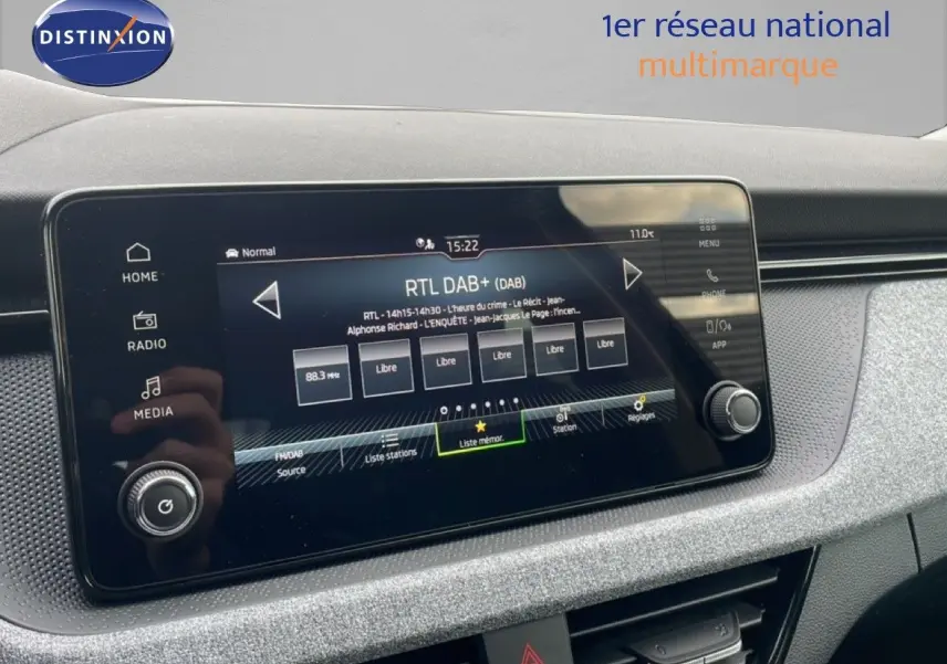 Vue rapprochée de l'écran tactile multimédia noir du tableau de bord du Skoda Kamiq 2025, affichant la radio DAB+.