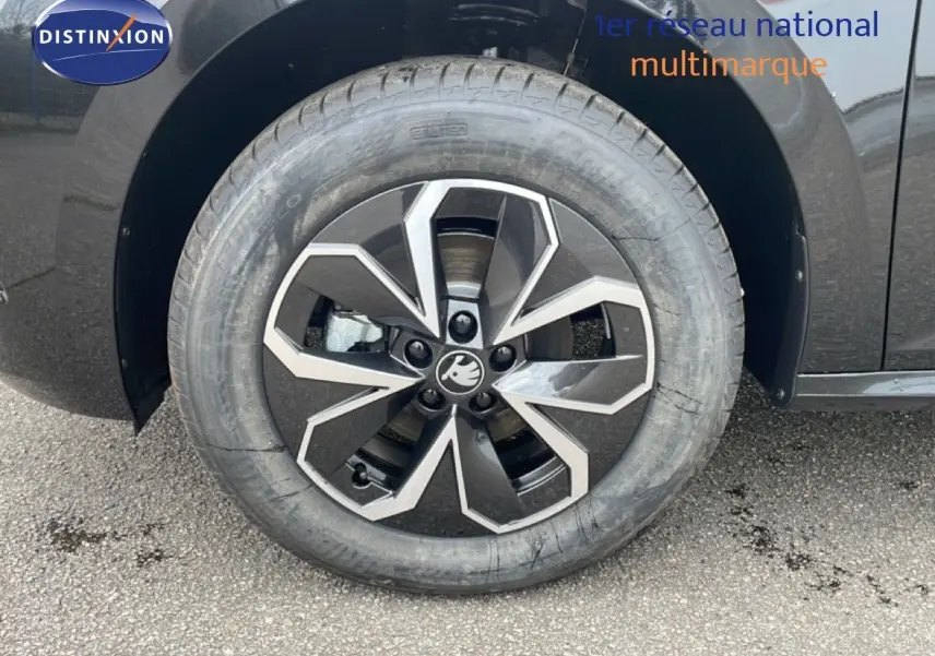 Gros plan sur la roue avant droite d'un Skoda Kamiq noir magique métal avec jante alliage au design géométrique.