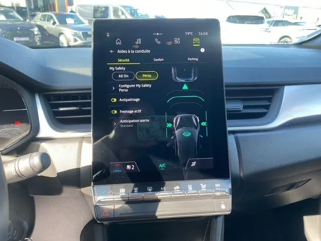 Vue intérieure centrée sur l'écran tactile vertical du tableau de bord du Renault Captur TCe 90 Evolution 2024, avec affichage des aides à la conduite.