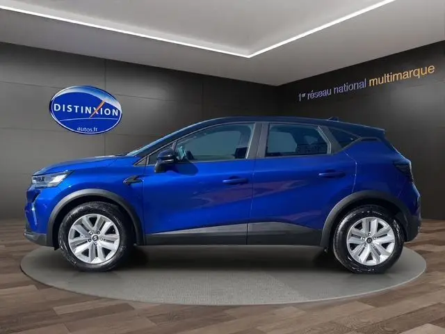 Vue latérale droite du Renault Captur TCE 90 Evolution 2024 en bleu iron avec toit noir, roues 17'' et coques de rétroviseurs noires.