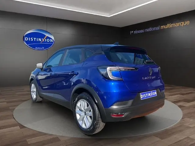Vue 3/4 arrière du Renault Captur 2024 bleuiron avec toit noir et feux arrière LED en forme de C.