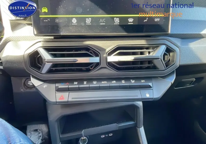 Vue rapprochée de la console centrale du Dacia Duster 2026 noire, montrant les aérateurs hexagonaux et commandes climatiques.