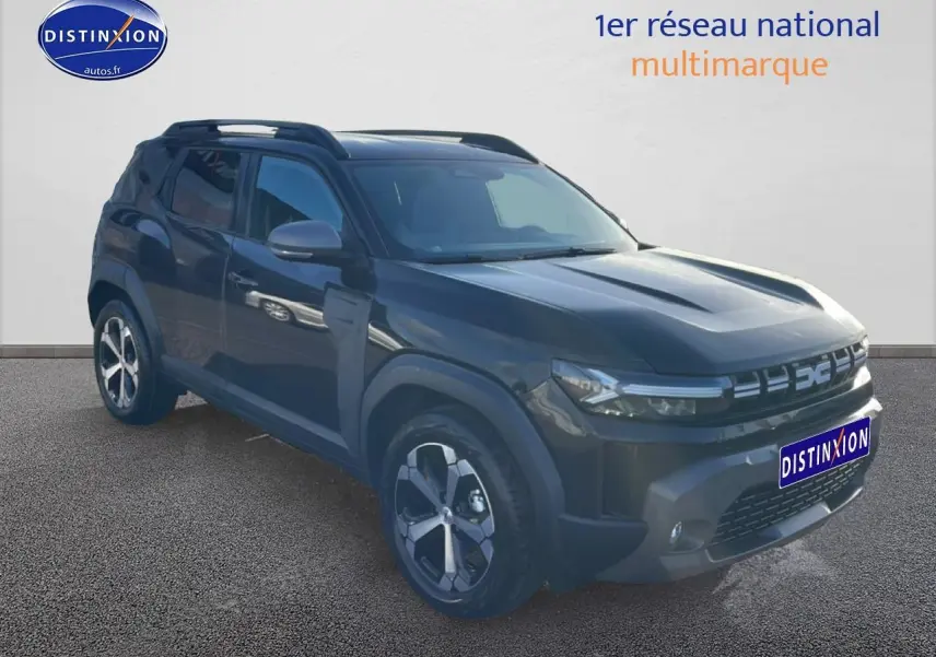 Dacia Duster noir 3/4 avant droit, jantes alu, barres de toit et calandre moderne avec logo lumineux.