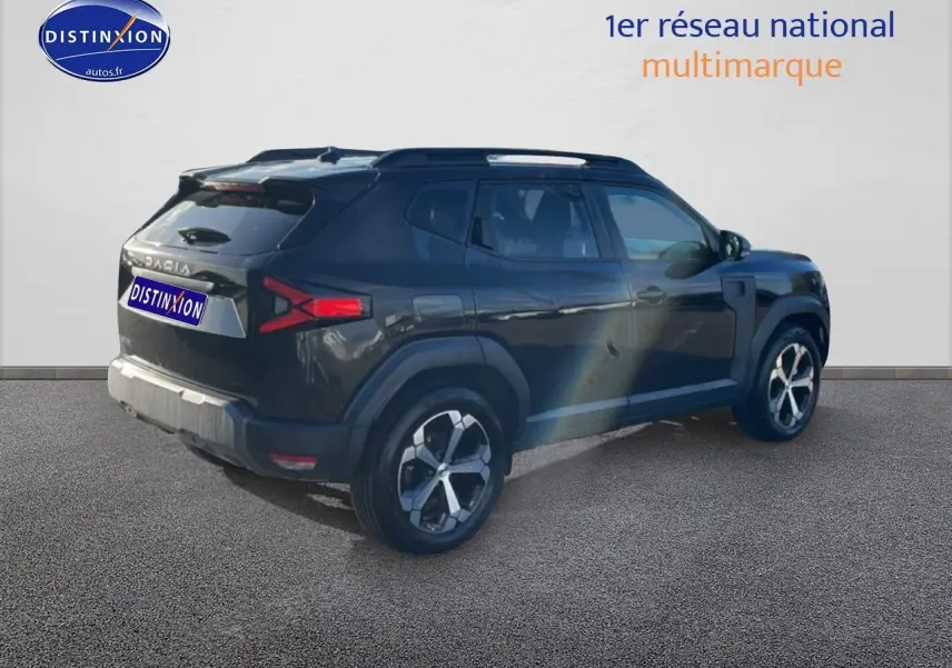 Vue 3/4 arrière droite d'un Dacia Duster noir avec barres de toit et jantes alliage modernes.
