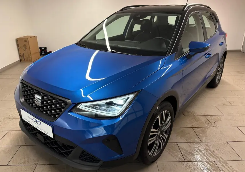 SEAT Arona bleu saphir avec toit noir, vue 3/4 avant droit mettant en valeur les phares LED et la calandre noire.