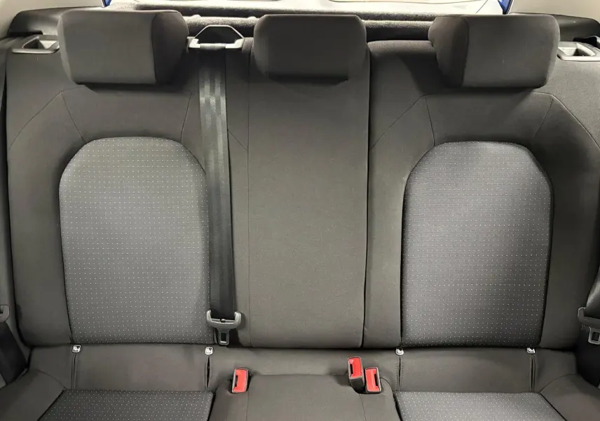 Vue intérieure de l'assise arrière du SEAT Arona 2025, tissu gris foncé avec motifs discrets et ceinture noire centrale.