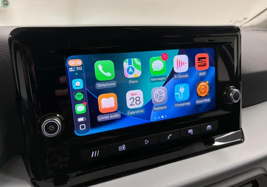 Écran tactile central du SEAT Arona 2025 affichant les applications connectées, entouré de commandes noires brillantes.