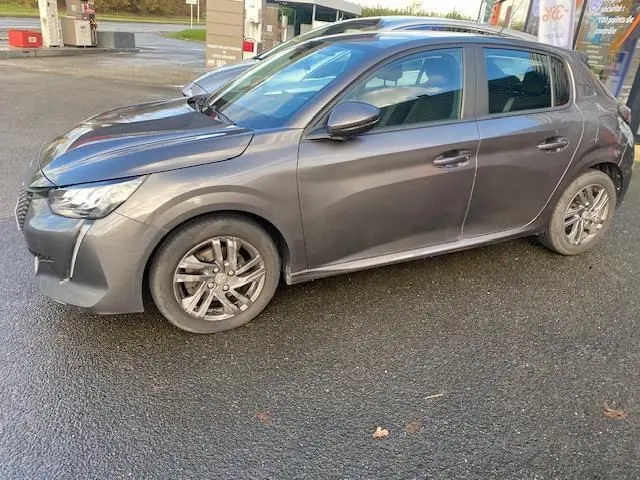 Peugeot 208 gris platinium vue de profil côté gauche, avec jantes alliage et feux avant LED visibles.