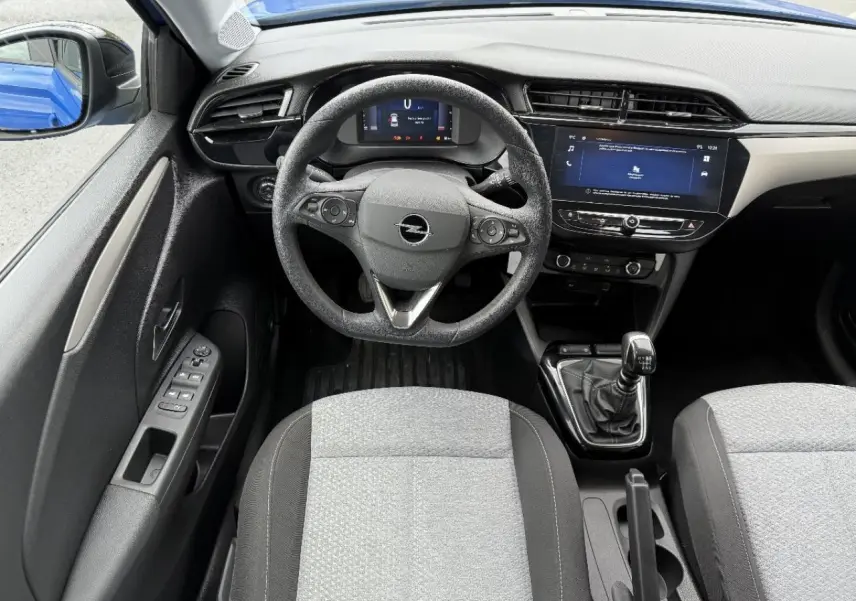 Vue intérieure centrée sur le volant Opel Corsa 2025, avec tableau de bord numérique et levier de vitesse manuel.